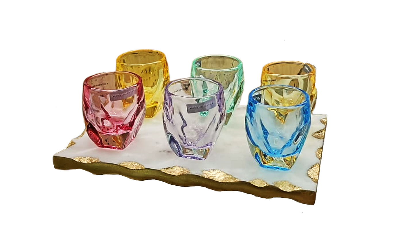 Set of colorful glass tumblers on a decorative tray with a white background